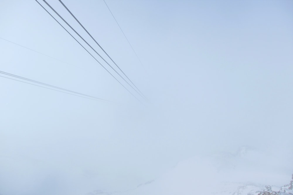 a ski lift going through a foggy sky