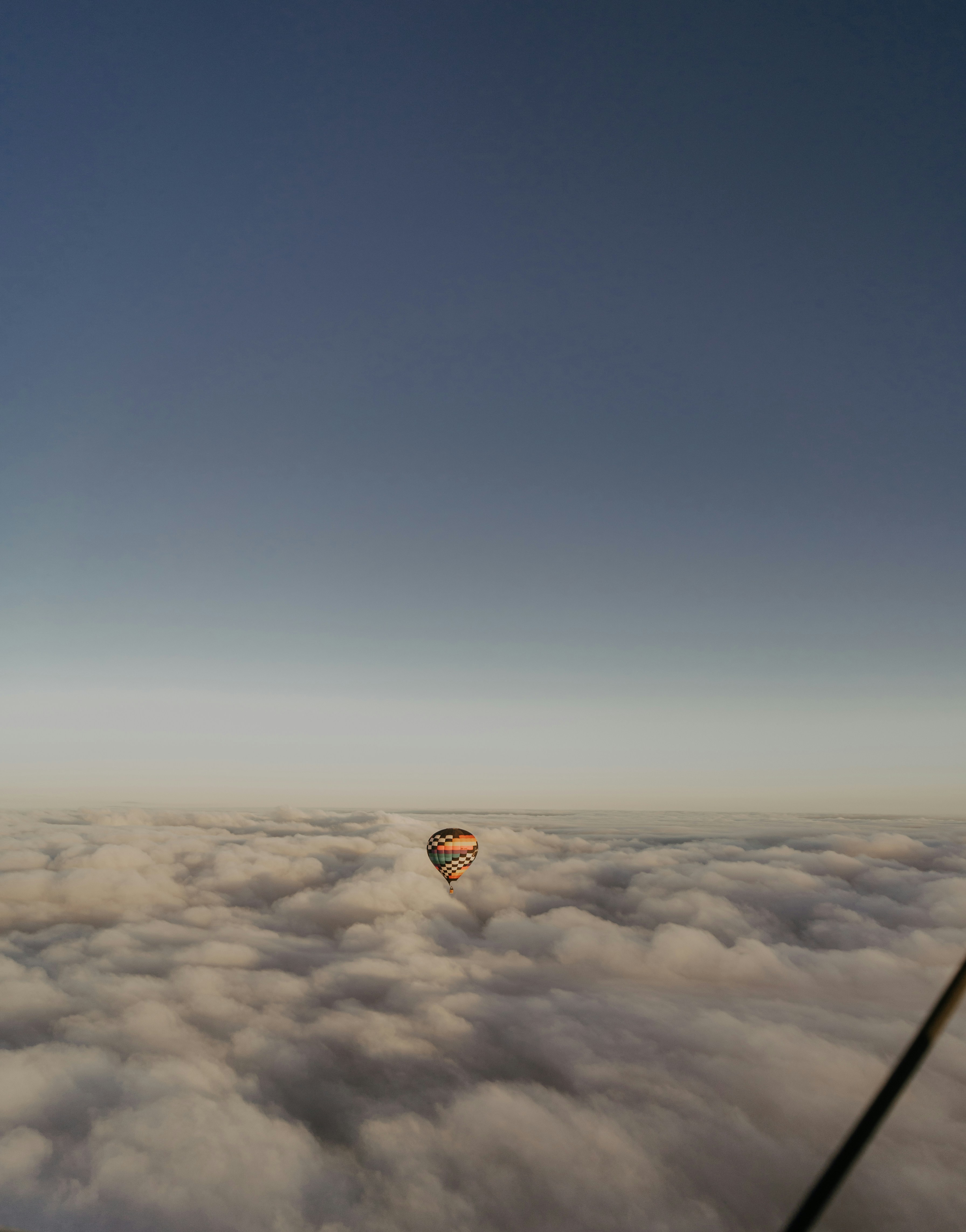 a hot air balloon flying above the clouds