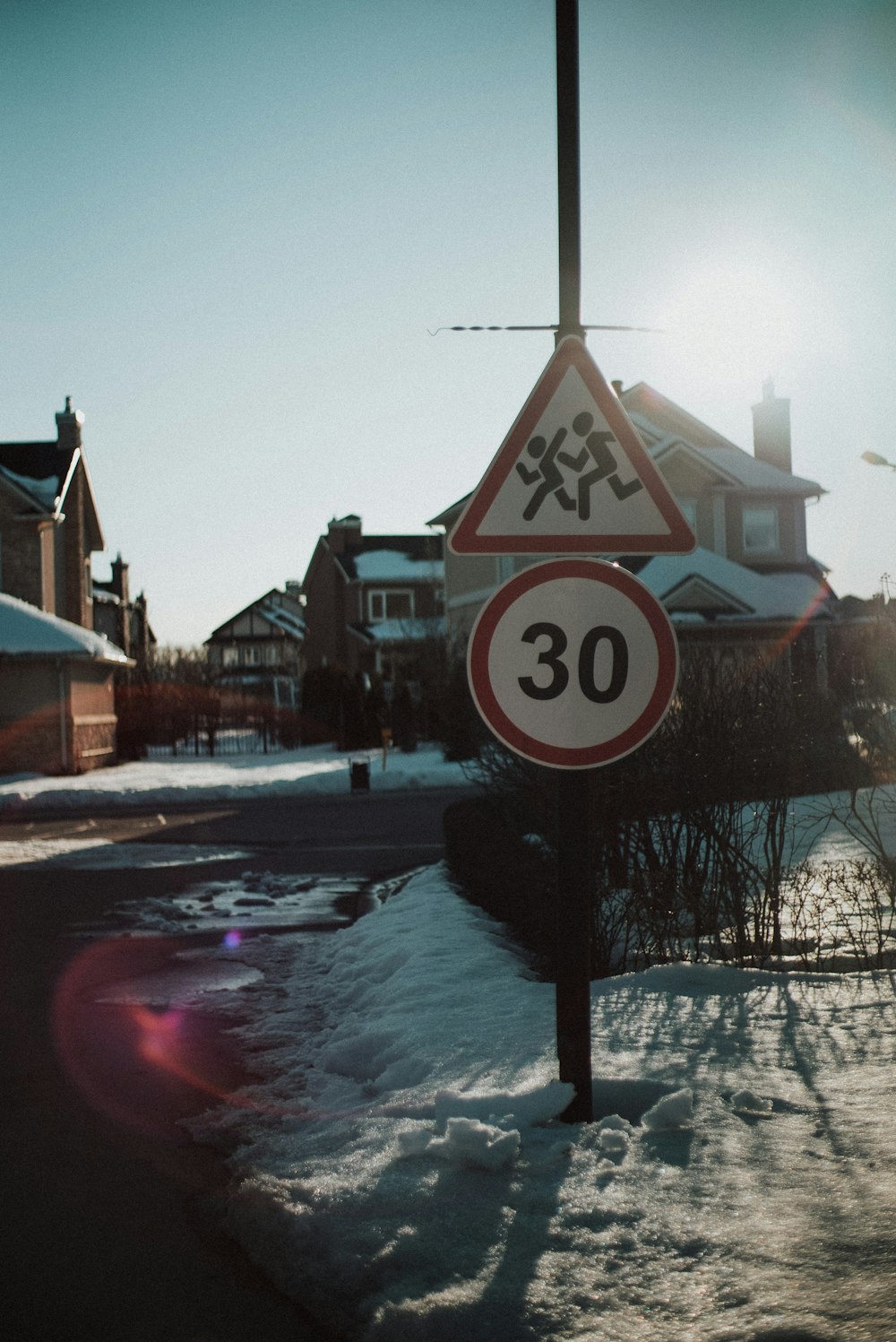 a street sign sitting on the side of a snow covered road