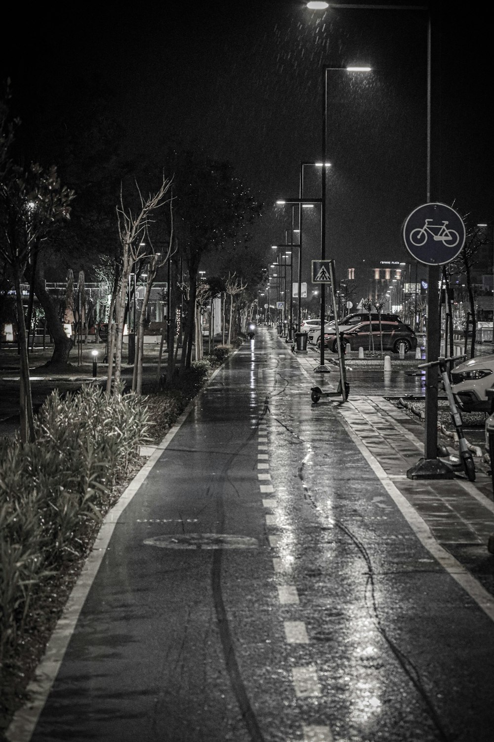 a black and white photo of a street at night