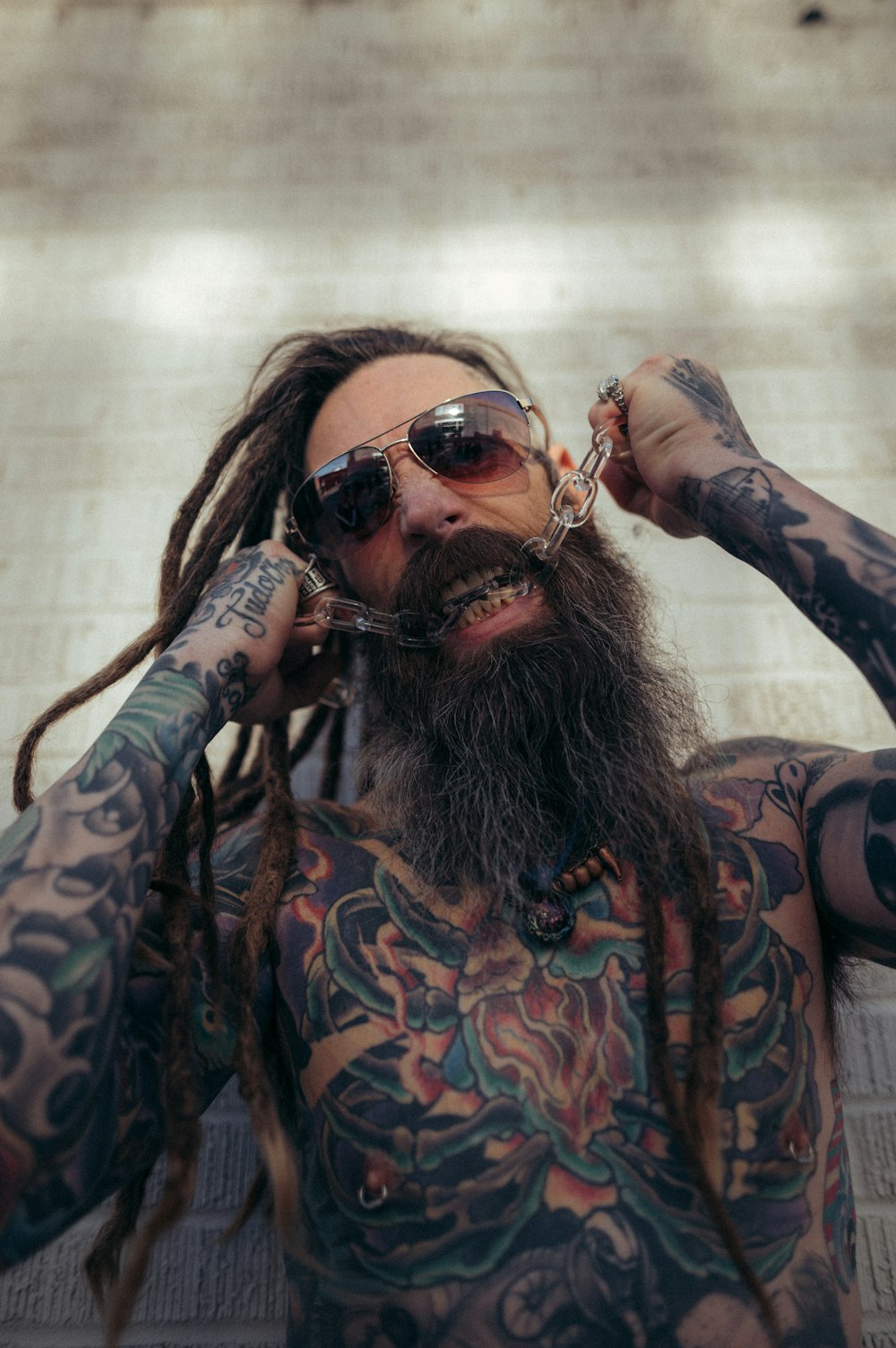 a man with a long beard and tattoos on his body