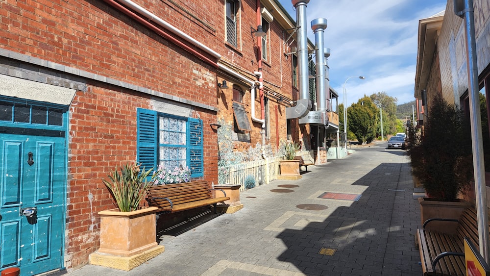 a wooden bench sitting next to a brick building