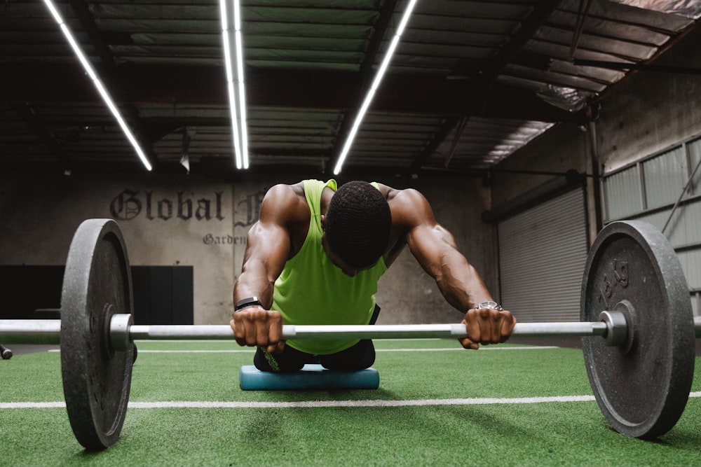 a man squatting on a barbell in a gym