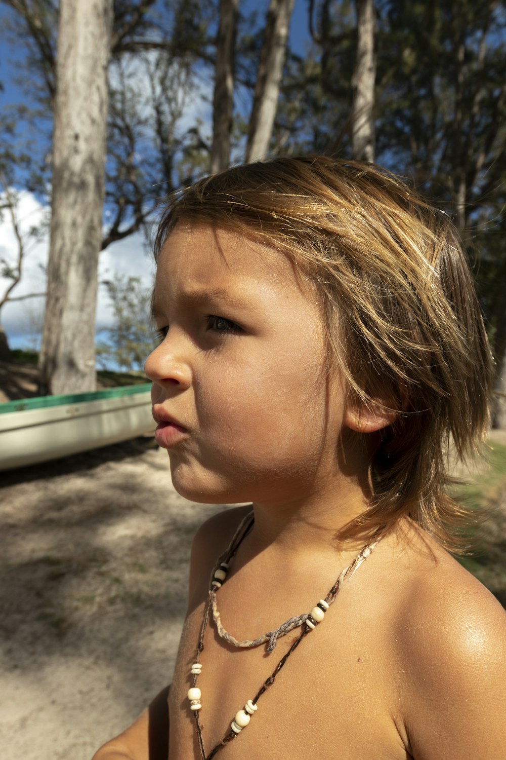 a young girl standing in front of a boat