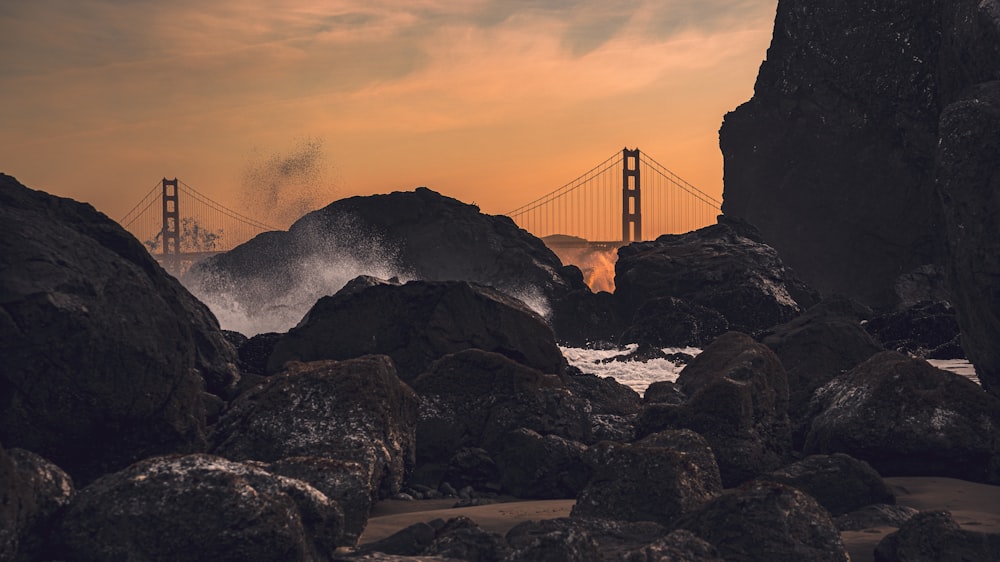 a view of the golden gate bridge from a rocky beach