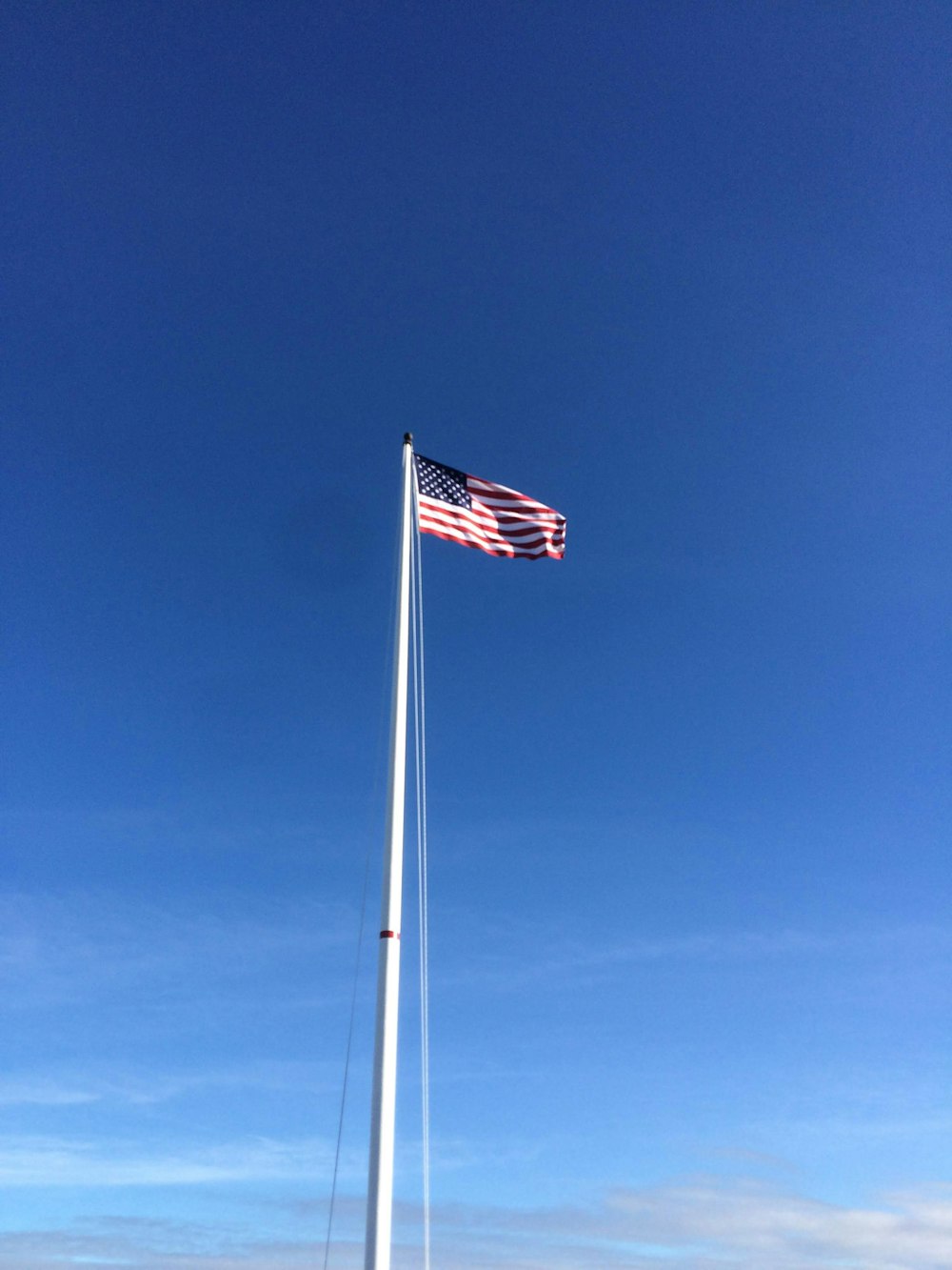a flag on a pole with a boat in the background