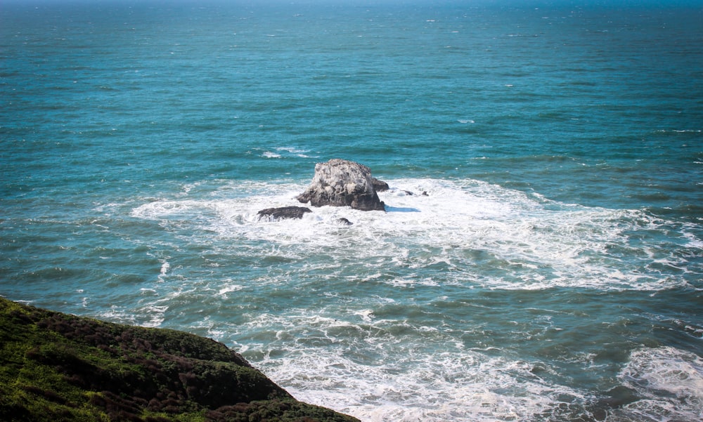 a large rock sticking out of the ocean