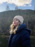 a woman standing in front of a body of water