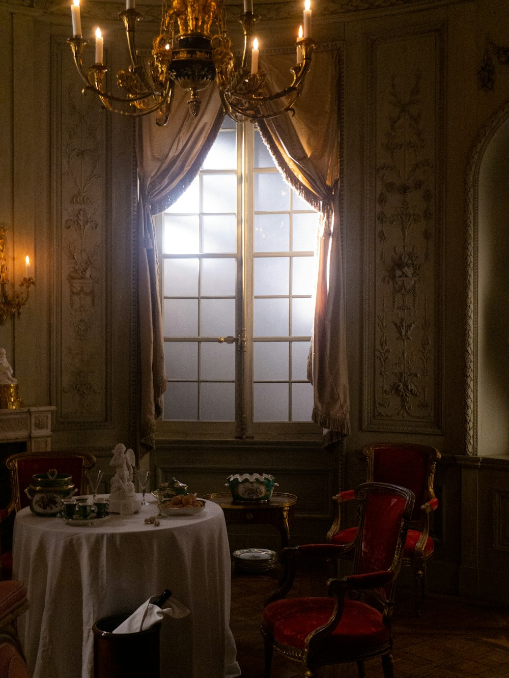 a dining room with a table, chairs and a chandelier