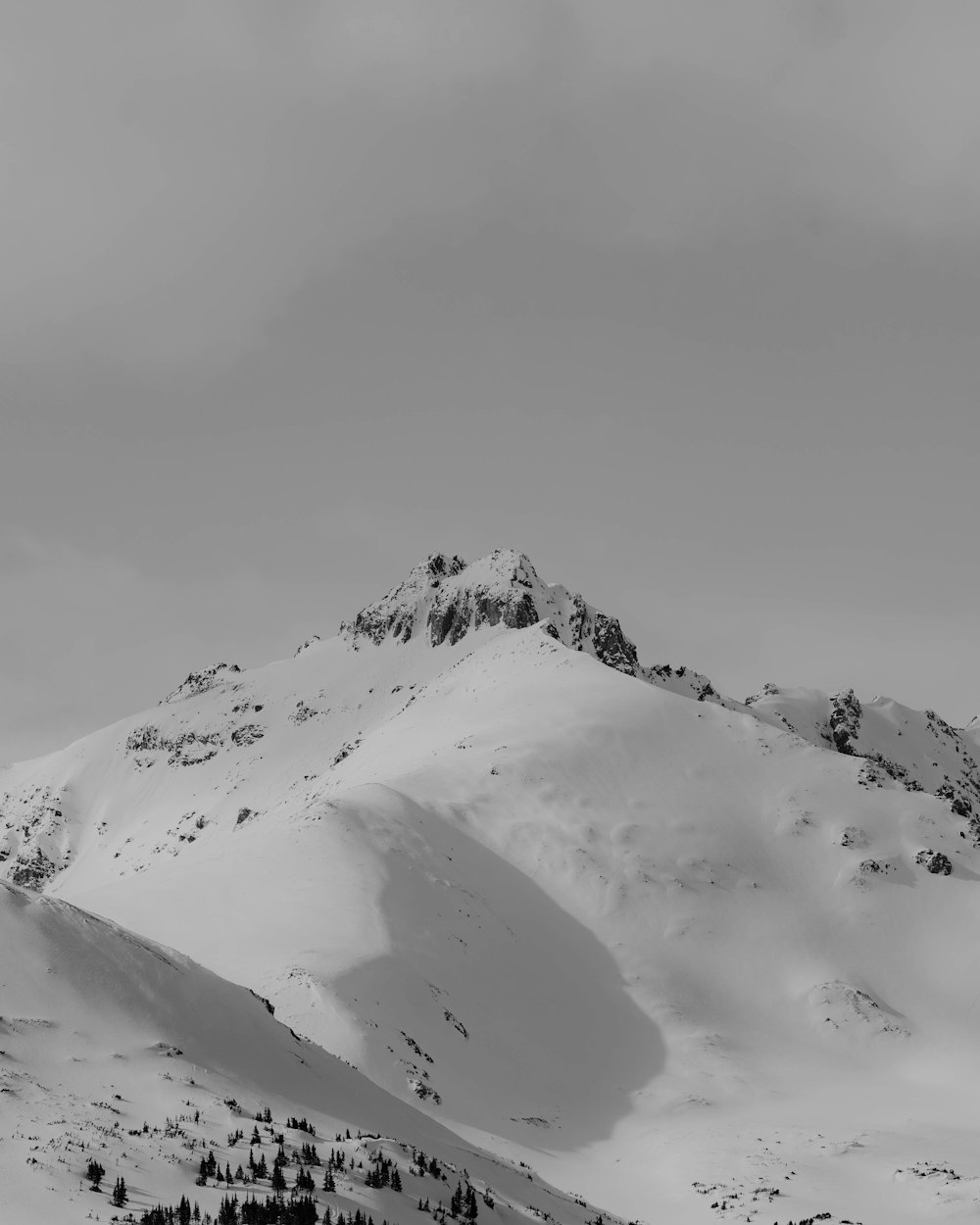 a black and white photo of a snowy mountain