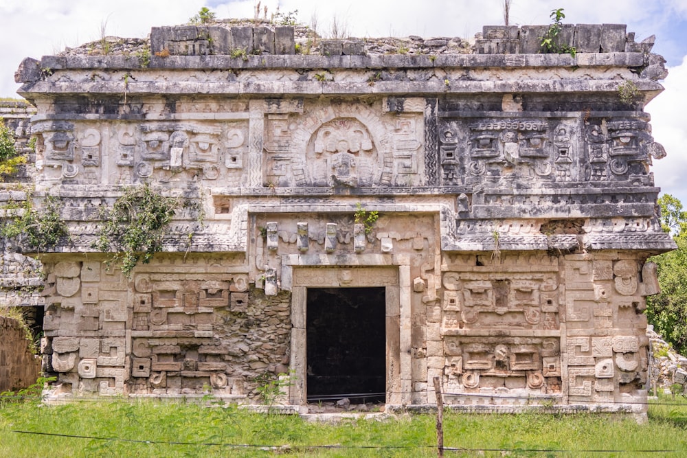 a stone building with a doorway and a clock on it