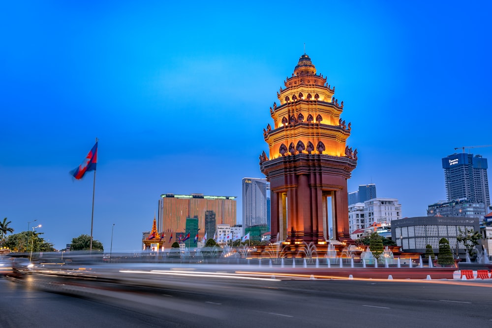 a tall clock tower sitting on the side of a road