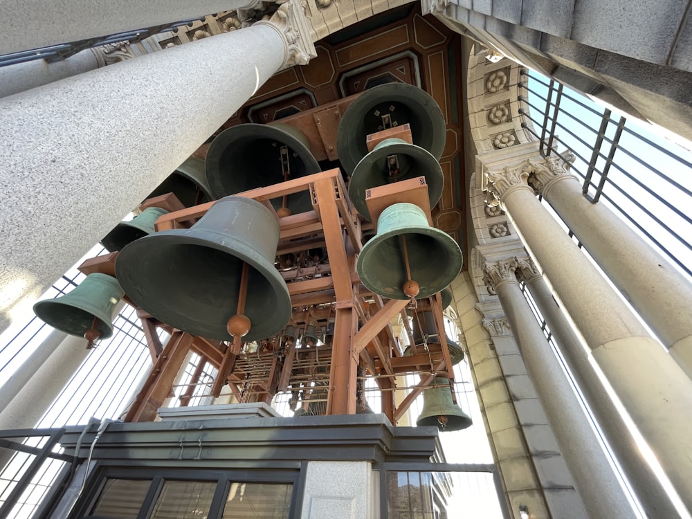 a group of bells hanging from the ceiling of a building