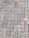 Interlocking concrete pavers form a repeated pattern on the ground, displaying a combination of muted gray and pink hues. Some greenery, possibly small patches of grass, peeks through the joints of the pavers.