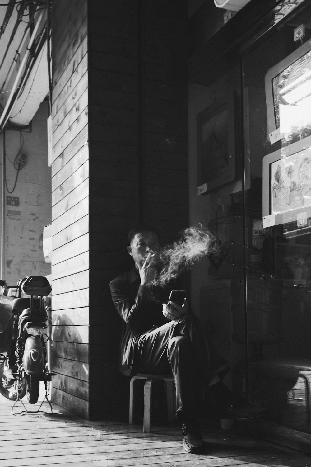 a man sitting on a bench smoking a cigarette