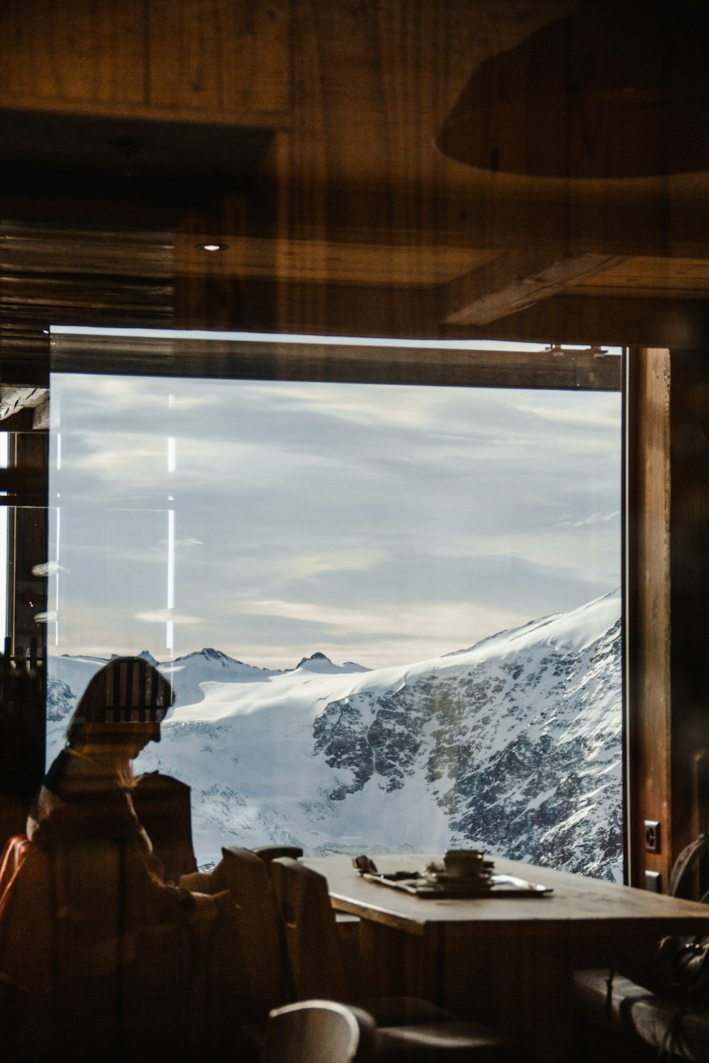 a person sitting at a table looking out a window