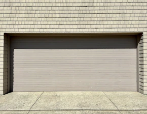 a white fire hydrant sitting in front of a garage door
