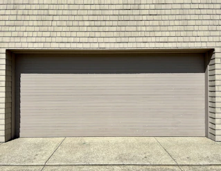 a white fire hydrant sitting in front of a garage door