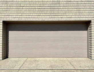a white fire hydrant sitting in front of a garage door