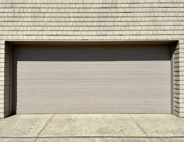 a white fire hydrant sitting in front of a garage door