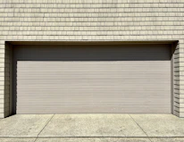 a white fire hydrant sitting in front of a garage door