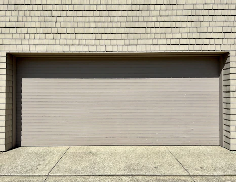 a white fire hydrant sitting in front of a garage door