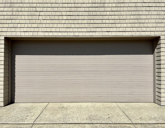 a white fire hydrant sitting in front of a garage door