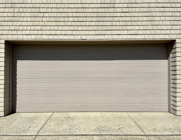 a white fire hydrant sitting in front of a garage door