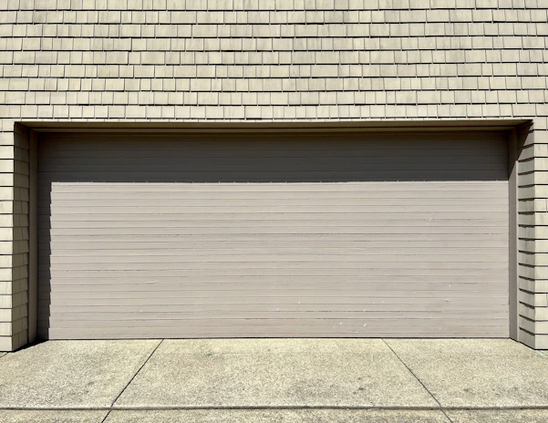 a white fire hydrant sitting in front of a garage door