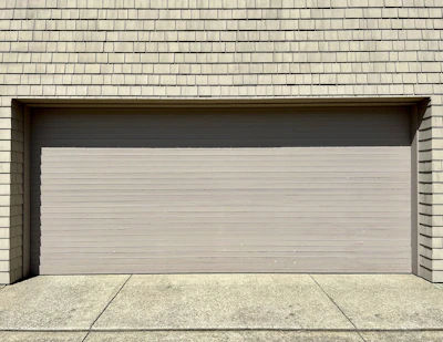 a white fire hydrant sitting in front of a garage door