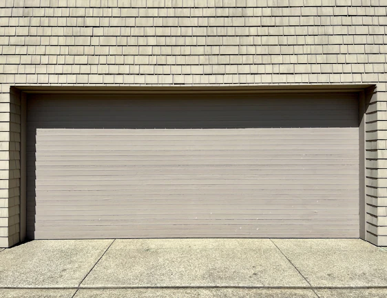 a white fire hydrant sitting in front of a garage door