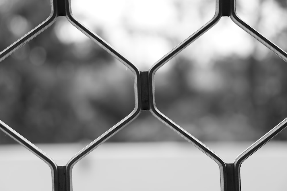 a black and white photo of a metal fence