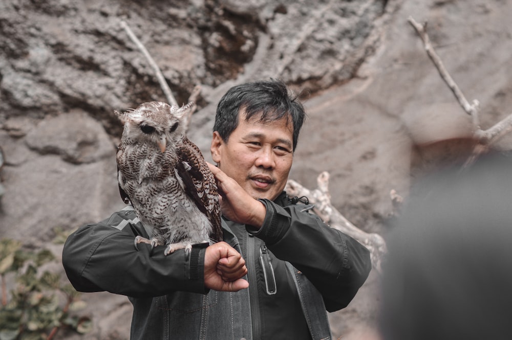 a man holding an owl in his hands