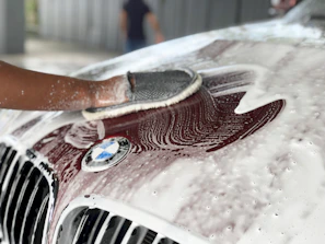 a person washing a car with a sponge