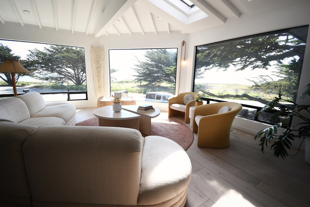 a living room filled with furniture and large windows