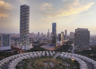 A high-rise residential tower in Delhi NCR with panoramic city views at sunset.