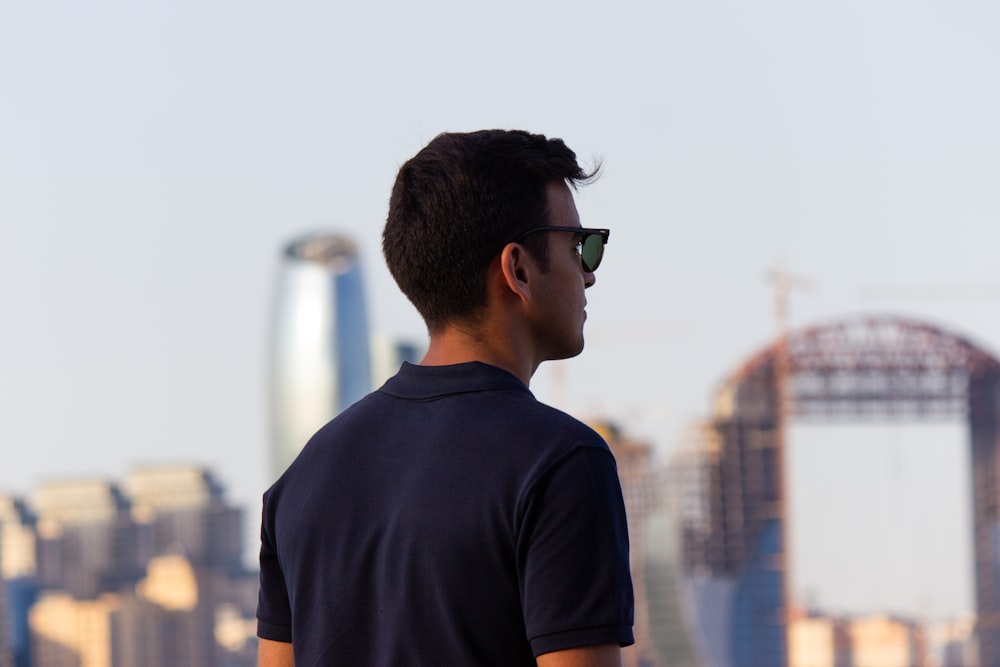 Un hombre con gafas de sol mirando la ciudad