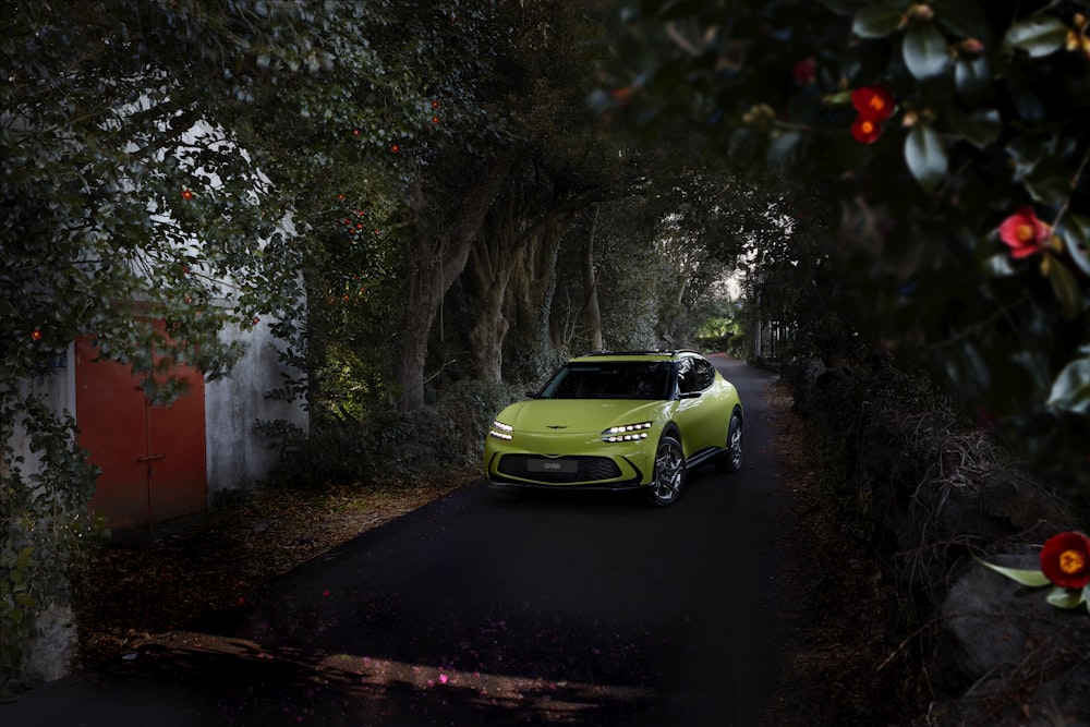 a green car driving down a dark street