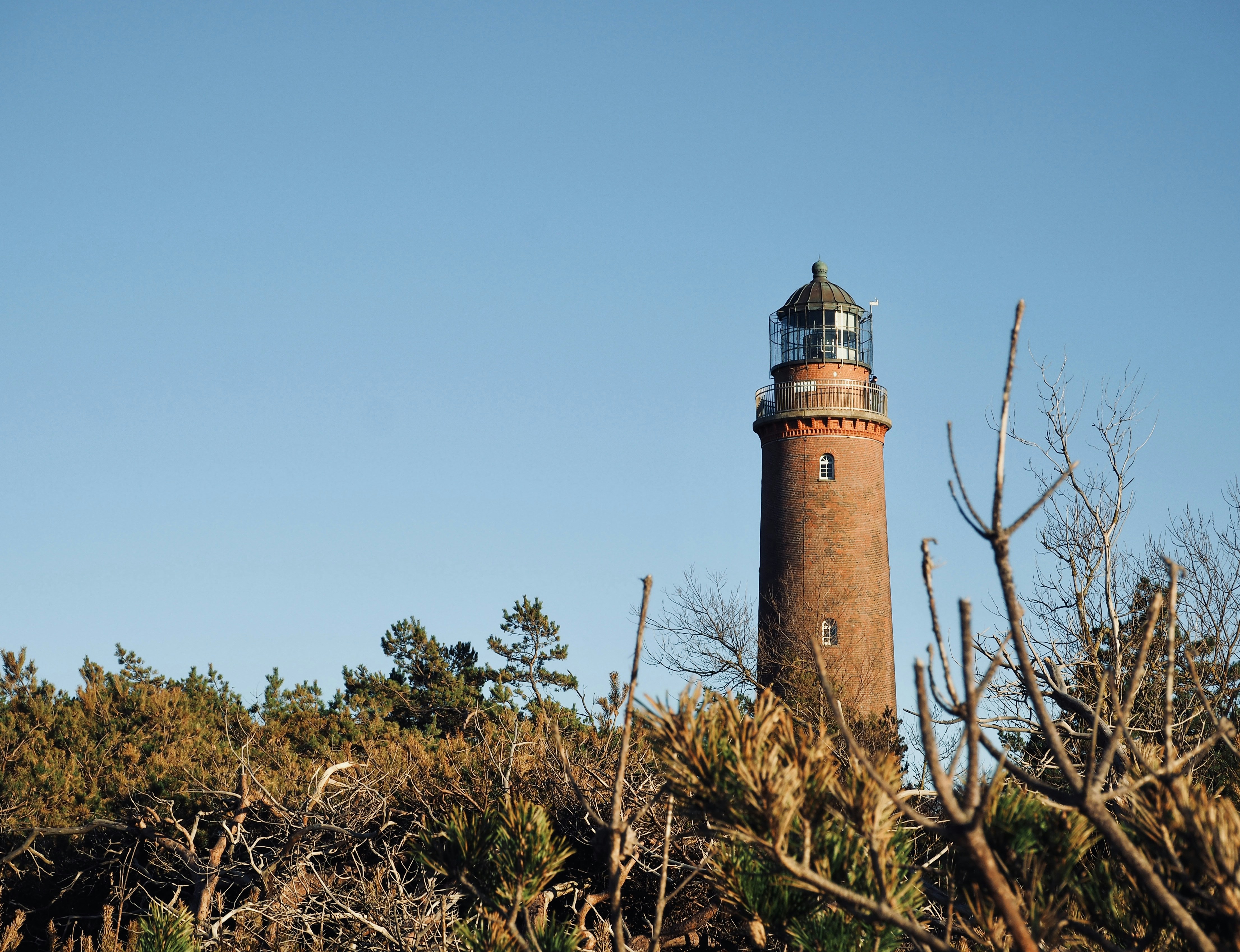 a light house sitting on top of a lush green hillside