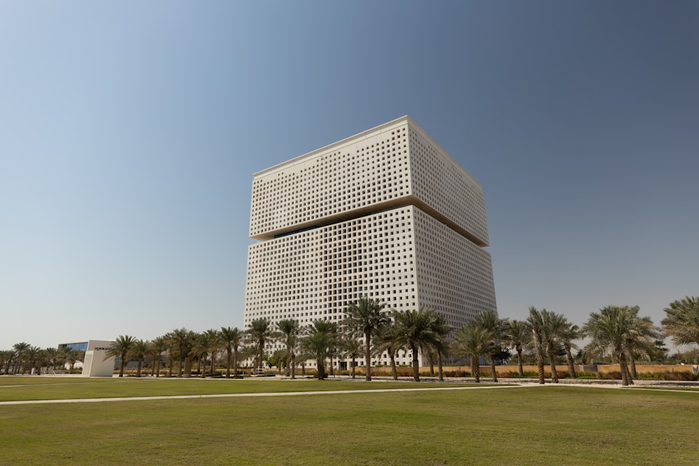 un grand bâtiment blanc assis au milieu d’un parc