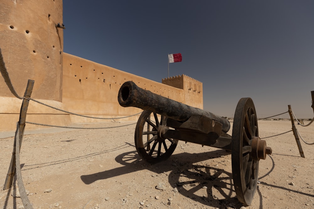 an old cannon sitting in the middle of a desert