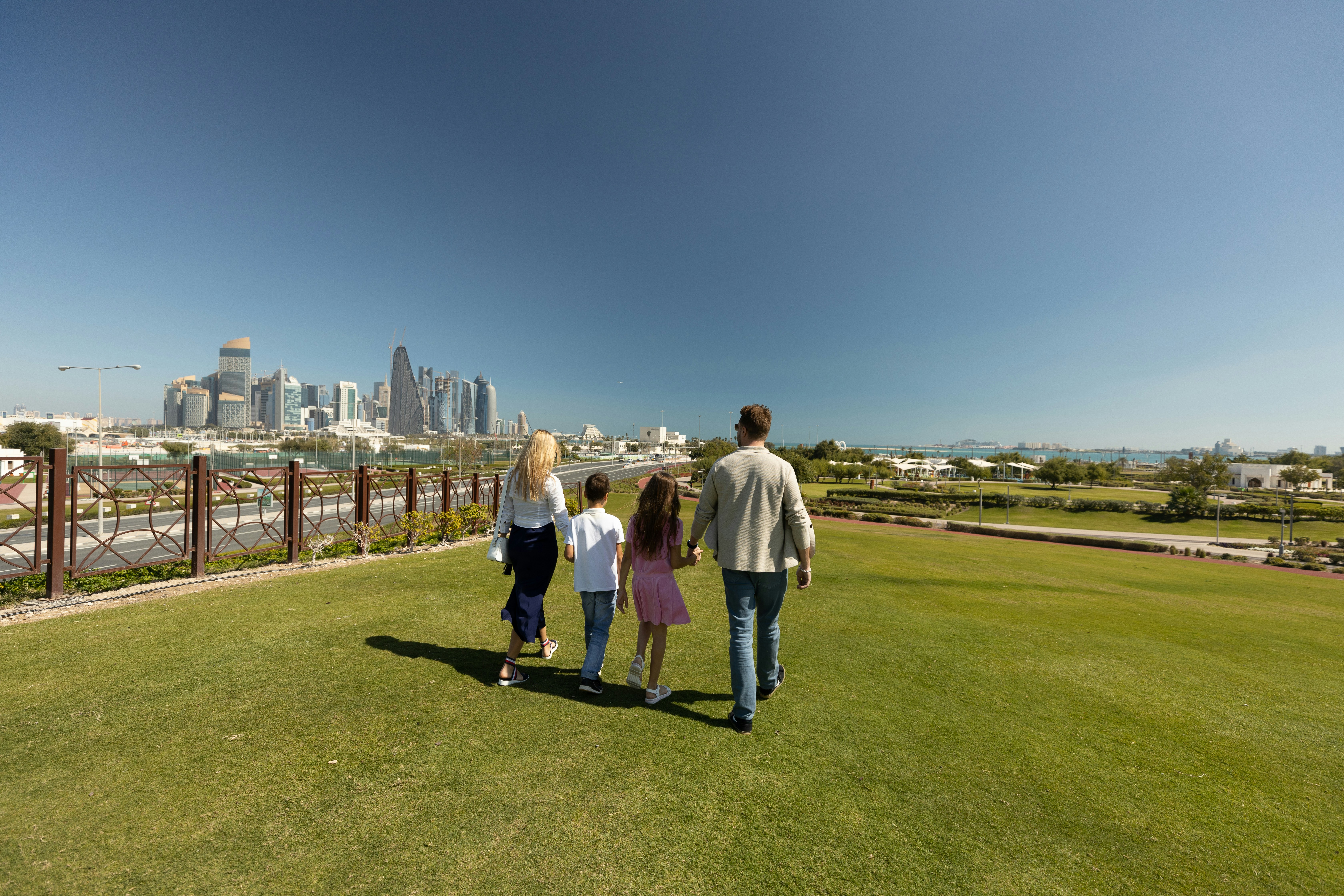 a group of people walking across a lush green field