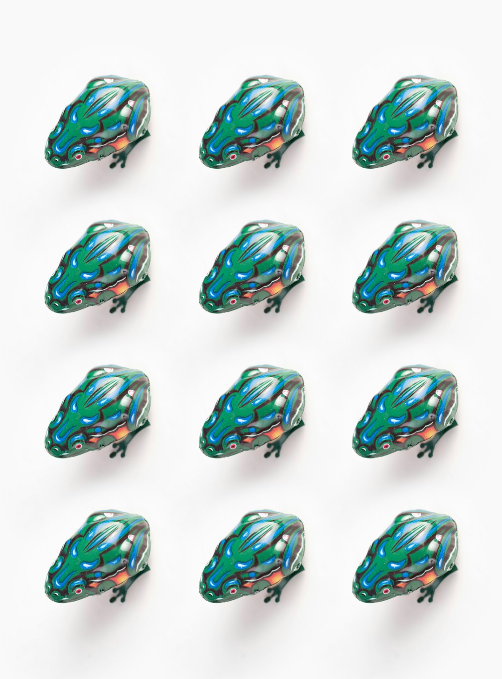 eine Gruppe von grünen und blauen Glasobjekten auf einer weißen Oberfläche