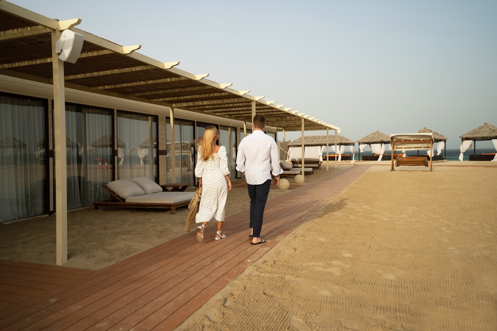 a man and a woman walking down a beach