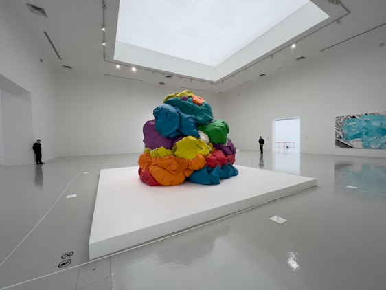 A bright, colorful abstract painting by Job Abednego David displayed in a minimalist gallery setting.