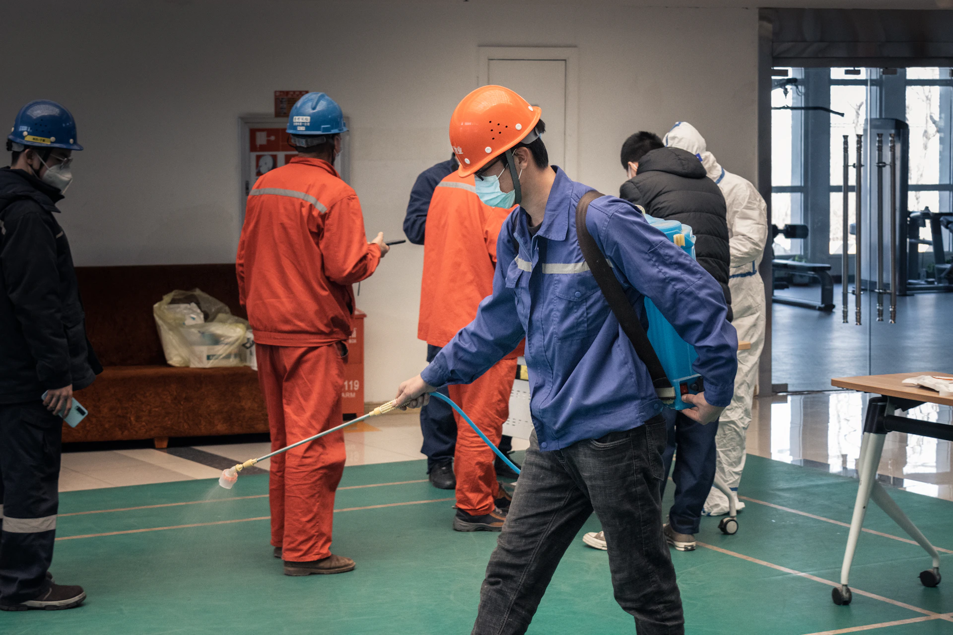 a group of people in orange jumpsuits and hard hats