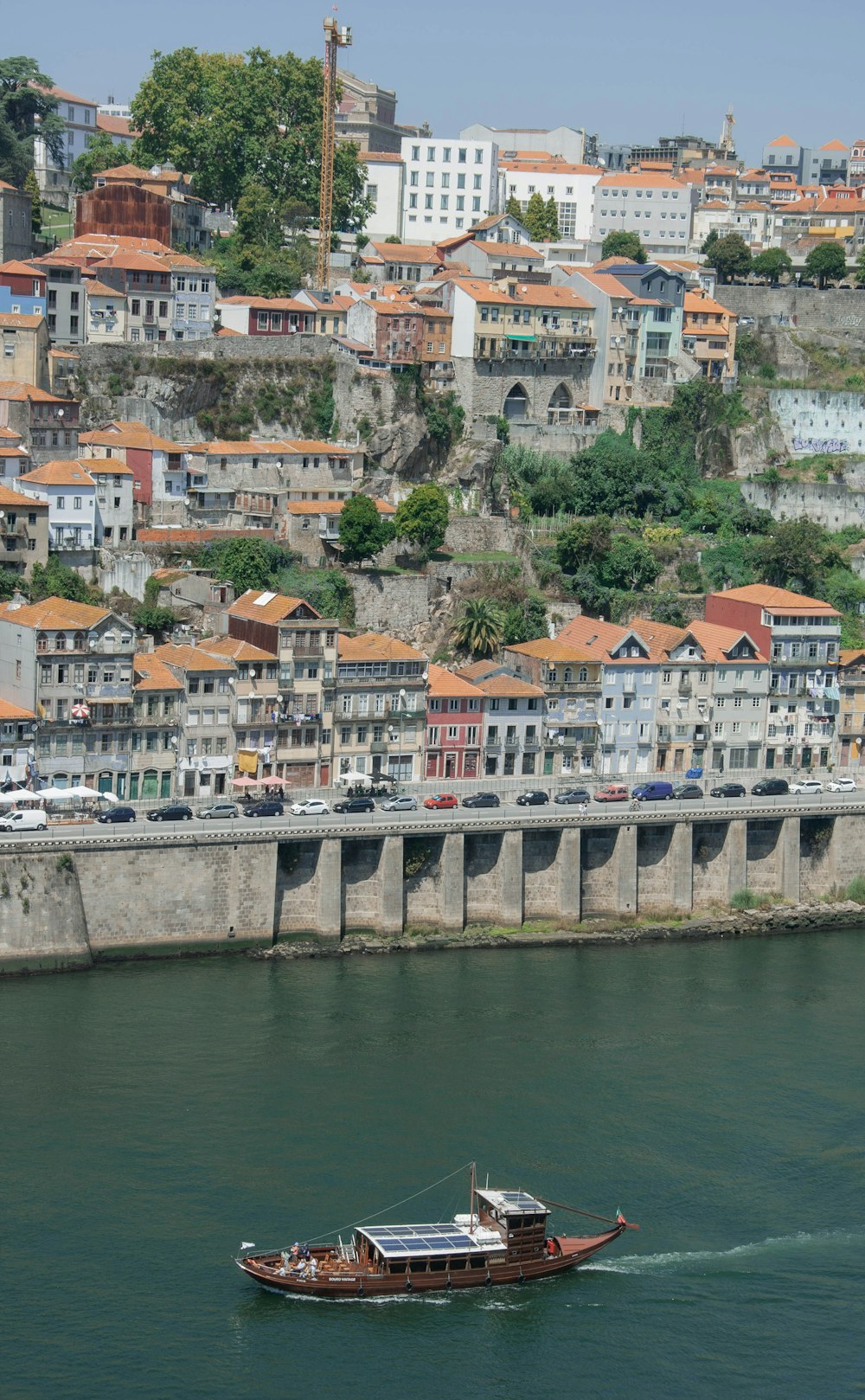 a boat traveling down a river next to a city