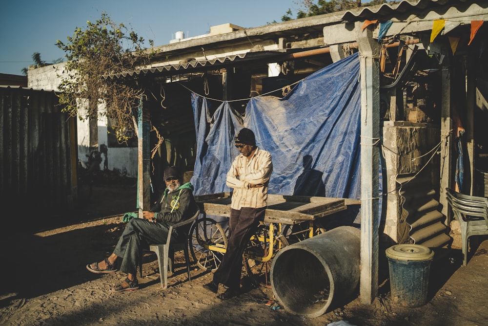 a man standing in front of a blue tarp