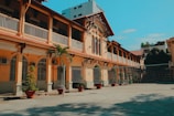 a tennis court in front of a yellow building