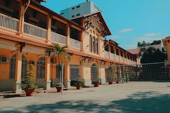a tennis court in front of a yellow building